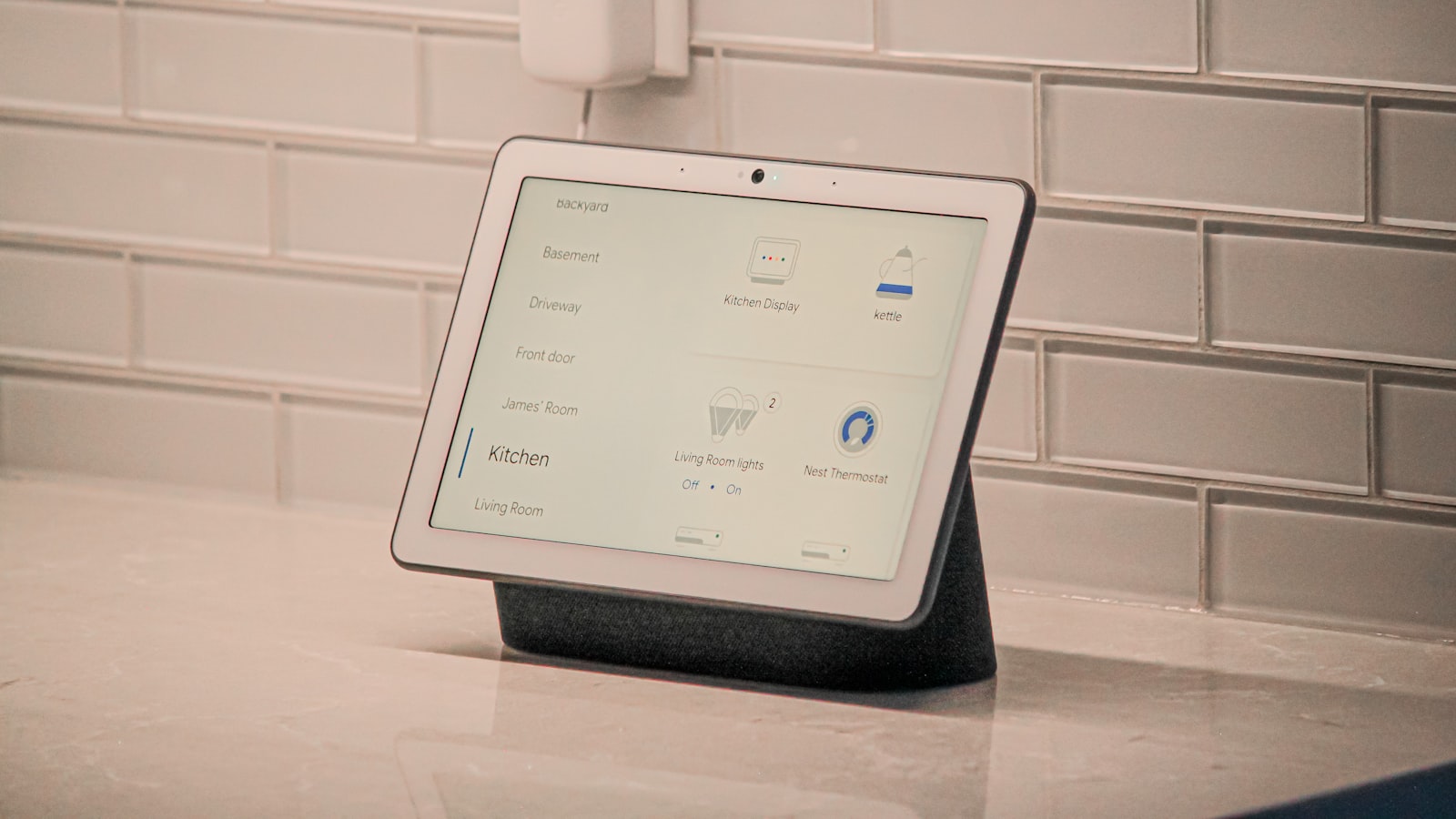 A smart display on a kitchen counter showing a smart home dashboard