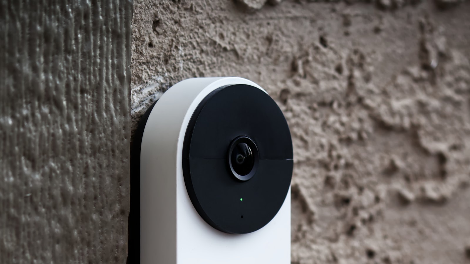 A video doorbell mounted on a wall beside a front door