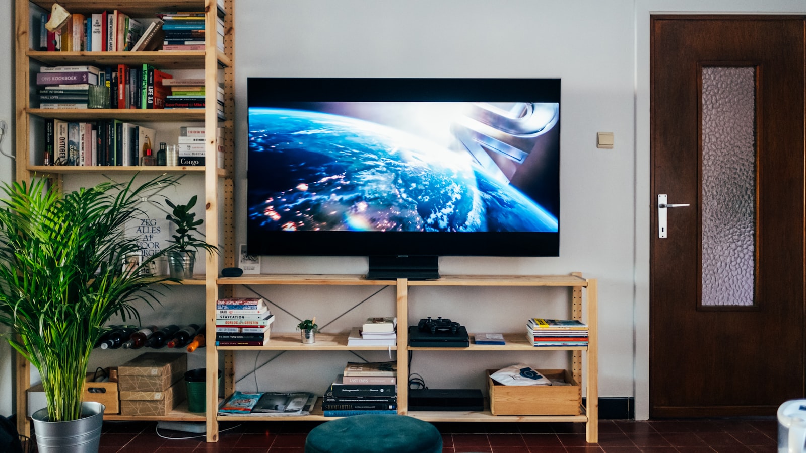 A wall-mounted television in a living room with a bookshelf